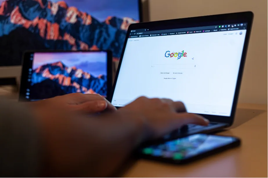 Hands using Google Search on a laptop